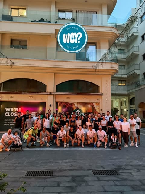 Around eighty runners in white club tees posing on a Larnaka street