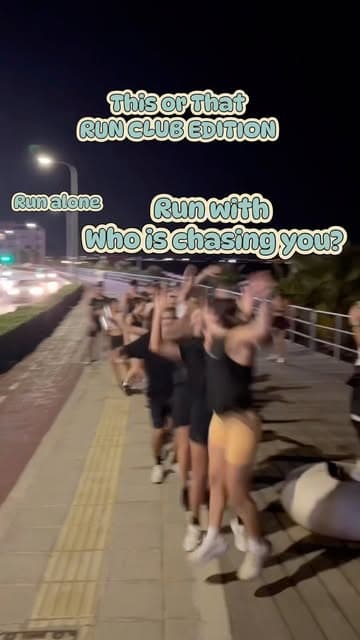 Runners jumping and cheering on the seafront at night